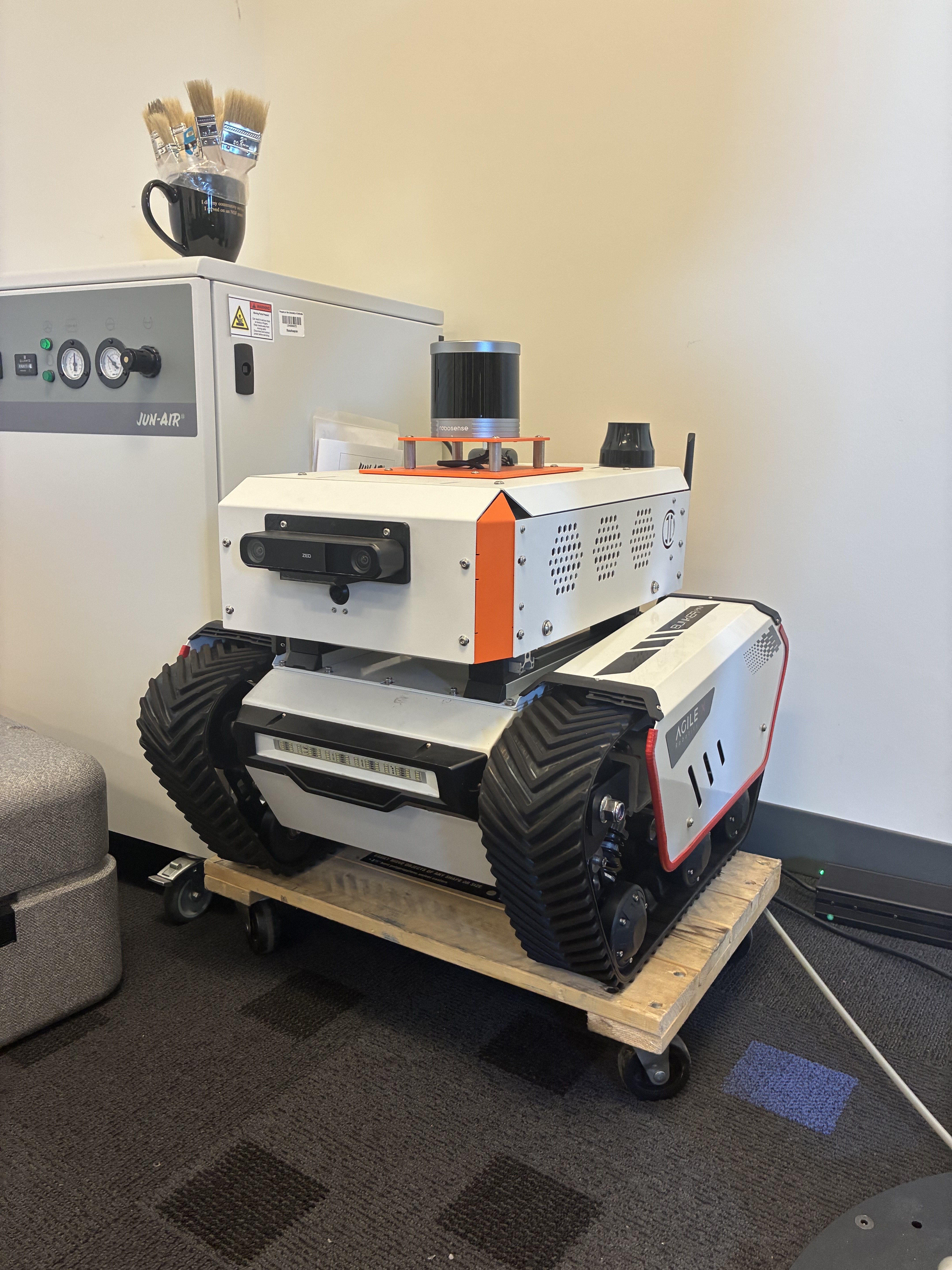The Bunker tracked ground robot carrying a rotating LiDAR unit and a stereo camera on its upper deck